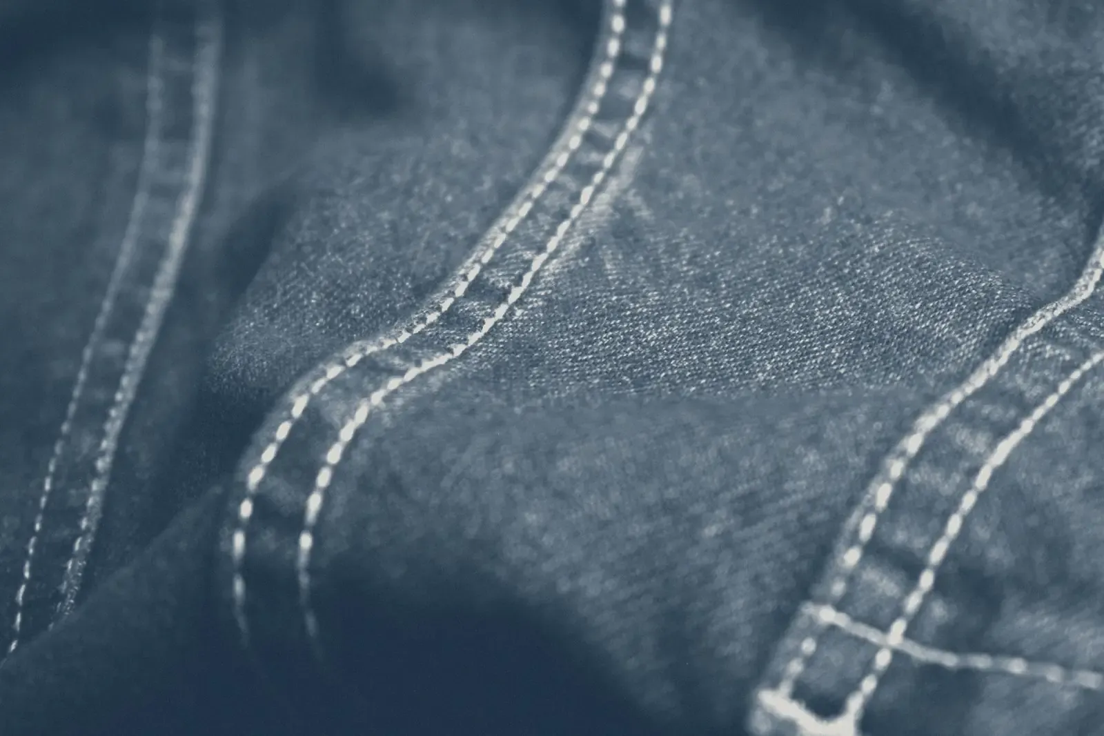 Close-up of denim stitching, in muted navy tones